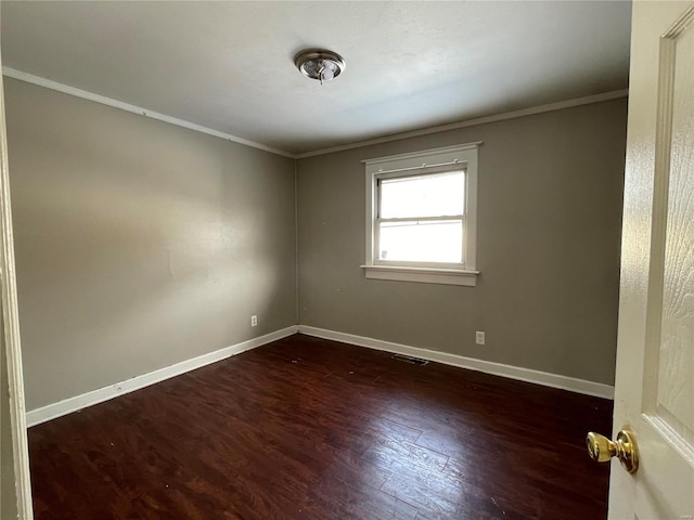 empty room featuring ornamental molding and dark hardwood / wood-style flooring