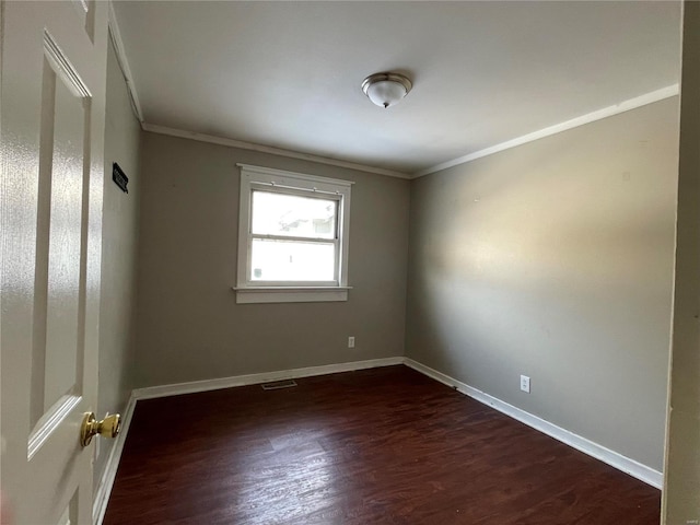 empty room featuring crown molding and dark hardwood / wood-style flooring