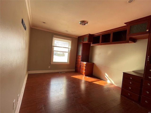 unfurnished bedroom featuring crown molding and wood-type flooring