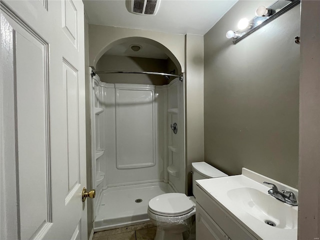 bathroom with vanity, toilet, a shower, and tile patterned floors