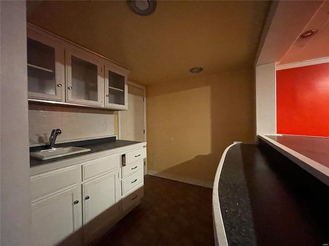 kitchen featuring sink, backsplash, and white cabinets