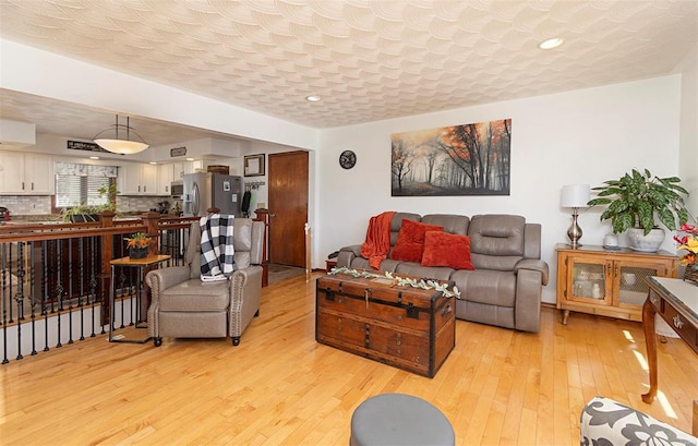 living room with light hardwood / wood-style floors and a textured ceiling