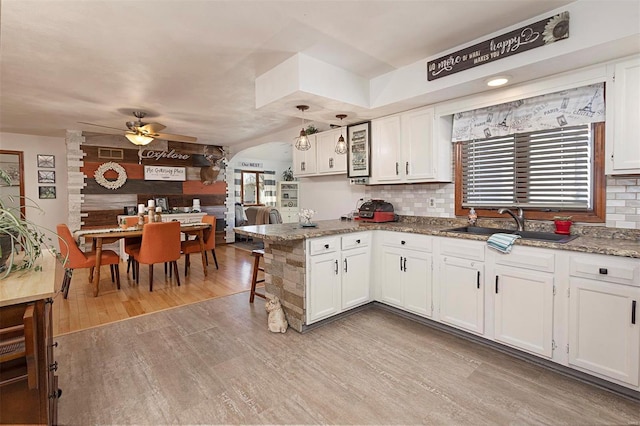 kitchen with light hardwood / wood-style floors, decorative backsplash, and white cabinets