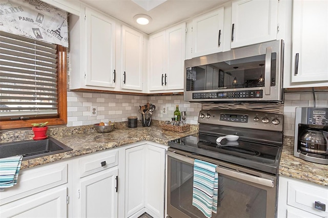 kitchen with white cabinetry, backsplash, stone counters, and appliances with stainless steel finishes