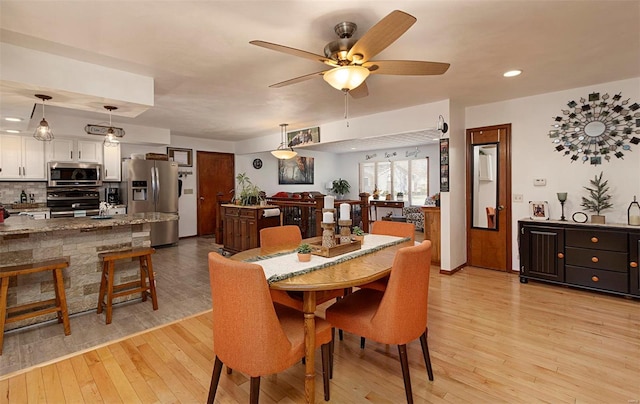 dining area featuring ceiling fan and light wood-type flooring