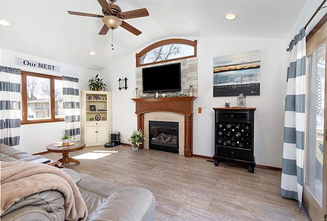 living room featuring ceiling fan, lofted ceiling, and light hardwood / wood-style floors