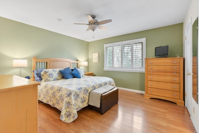 bedroom with a ceiling fan, visible vents, light wood-style flooring, and baseboards