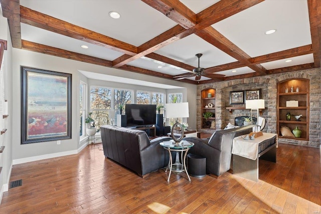 living room featuring built in features, a fireplace, hardwood / wood-style flooring, coffered ceiling, and beam ceiling