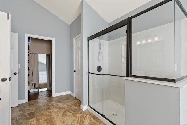 bathroom with a shower with door and vaulted ceiling