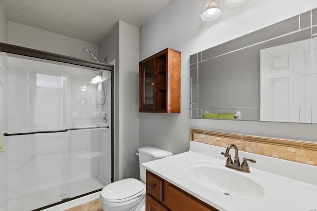 bathroom featuring walk in shower, vanity, toilet, and tile patterned flooring