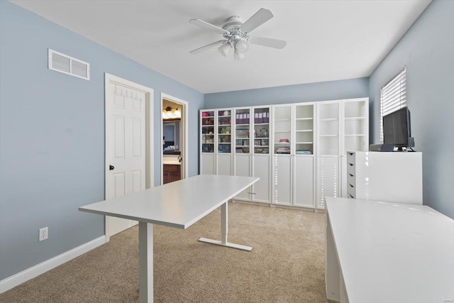 unfurnished office featuring light colored carpet and ceiling fan