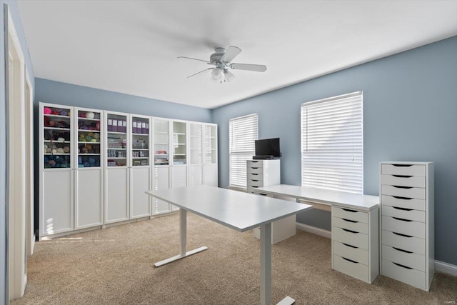 unfurnished office featuring ceiling fan and light carpet