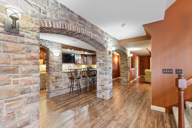 interior space featuring hardwood / wood-style floors, decorative columns, and sink