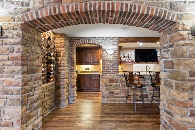 bar with wood-type flooring and sink