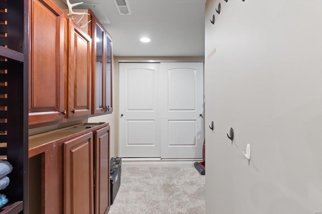 laundry area with light colored carpet