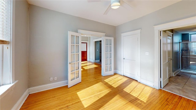 unfurnished bedroom with french doors, ceiling fan, light hardwood / wood-style floors, and a closet