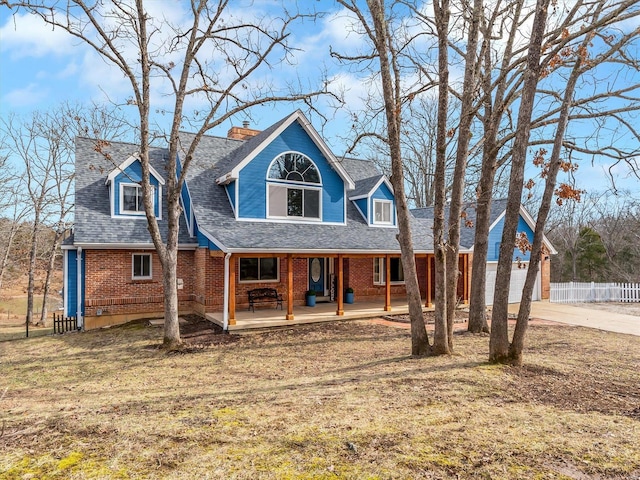 cape cod house featuring a porch and a front lawn