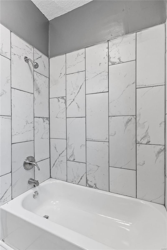 bathroom featuring a textured ceiling and  shower combination