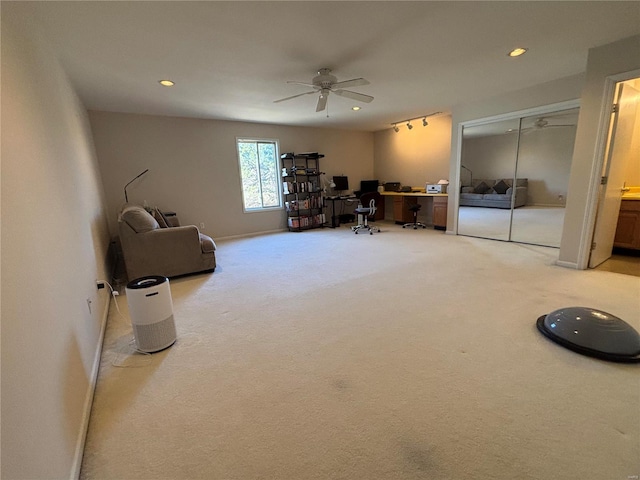 interior space featuring ceiling fan, rail lighting, and carpet