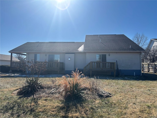 back of property featuring a wooden deck and a yard