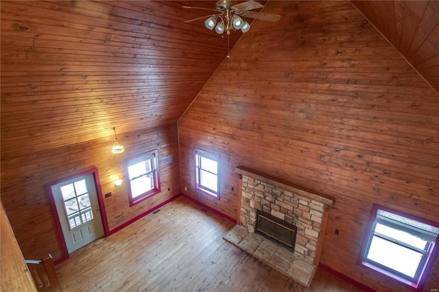 unfurnished living room with vaulted ceiling, ceiling fan, a fireplace, wooden ceiling, and hardwood / wood-style floors