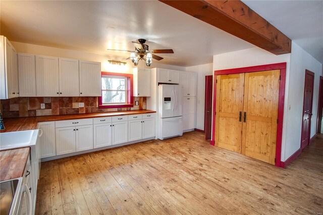 kitchen with butcher block countertops, white cabinets, tasteful backsplash, and white refrigerator with ice dispenser