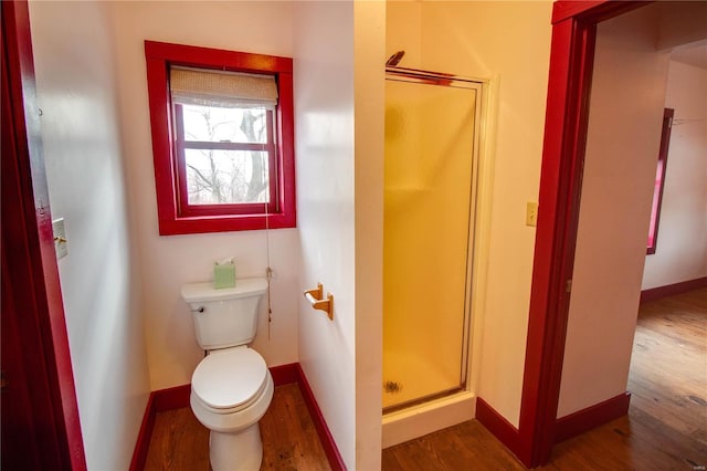 bathroom with toilet, hardwood / wood-style floors, and an enclosed shower