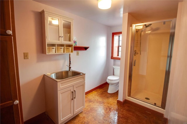 bathroom featuring a shower with door, toilet, and vanity