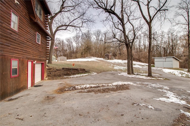 yard covered in snow featuring a garage