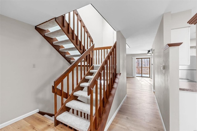 stairs featuring hardwood / wood-style floors and ceiling fan