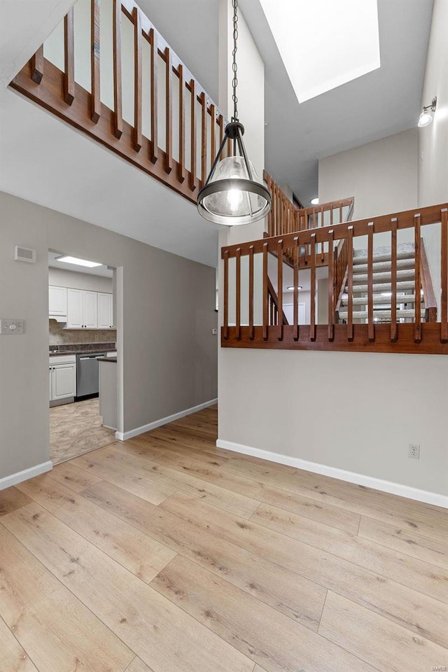 staircase with hardwood / wood-style floors and a skylight