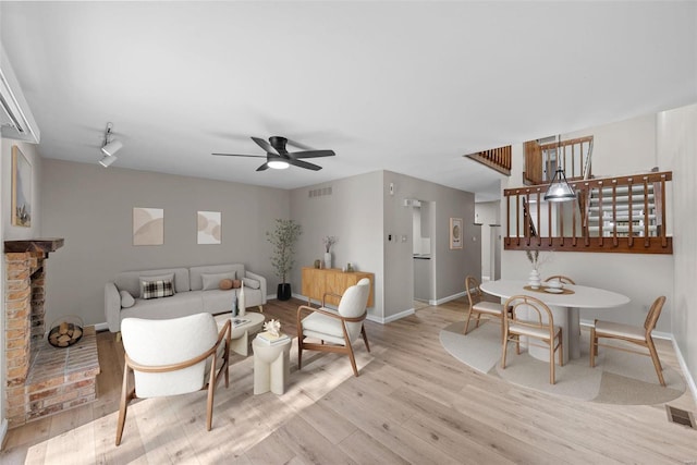 interior space featuring ceiling fan, a fireplace, and light hardwood / wood-style floors