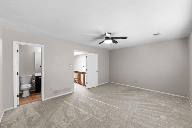 unfurnished bedroom with ceiling fan, ensuite bath, and light colored carpet