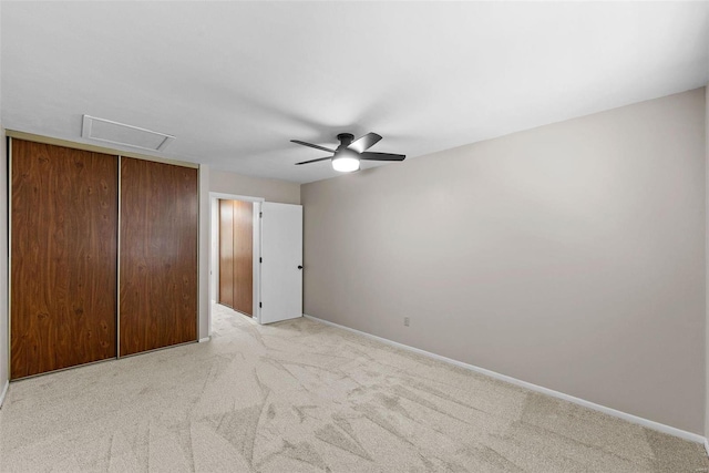 unfurnished bedroom with light colored carpet, a closet, and ceiling fan