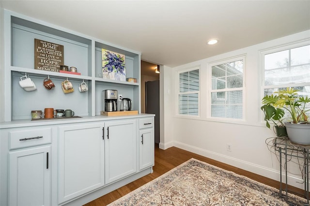 bar with white cabinetry and dark wood-type flooring