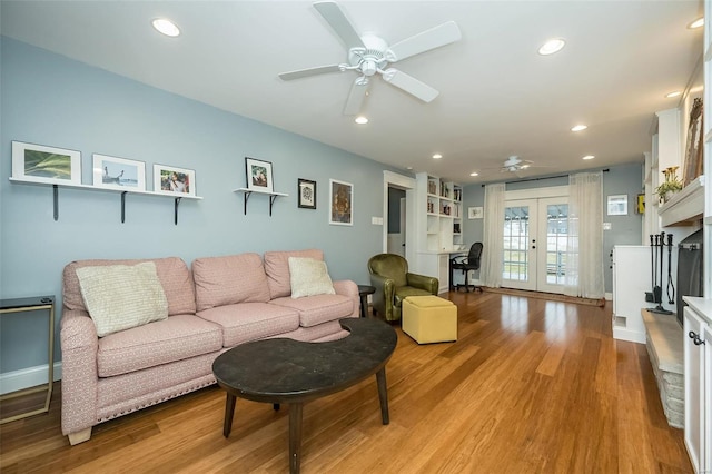 living room with ceiling fan, light hardwood / wood-style floors, and french doors