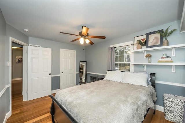 bedroom featuring ceiling fan, wood-type flooring, and a closet