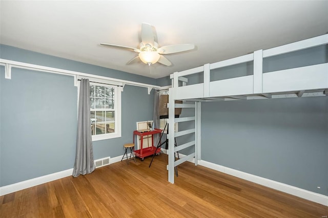 unfurnished bedroom featuring wood-type flooring and ceiling fan