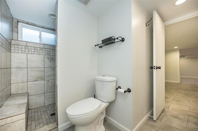 bathroom with toilet and a tile shower