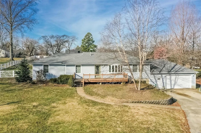 rear view of house with a yard, a deck, and a garage