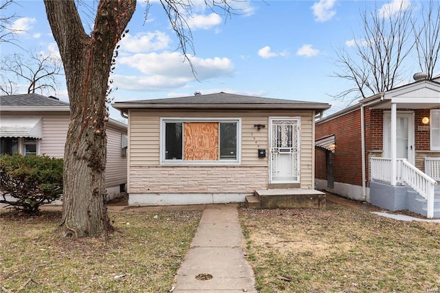 bungalow-style house with a front lawn