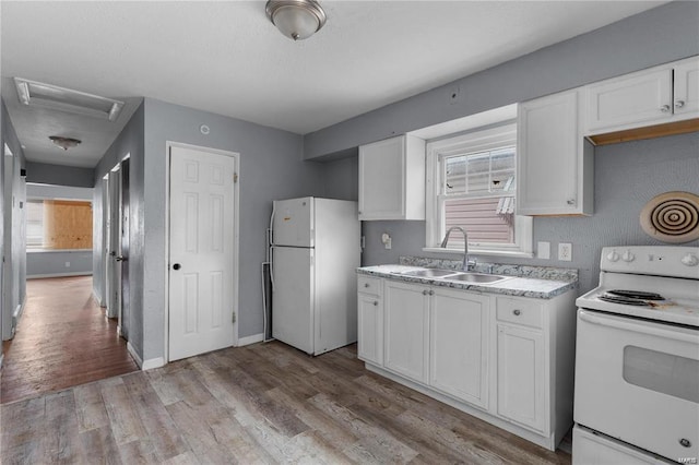 kitchen with light hardwood / wood-style floors, sink, white appliances, and white cabinets