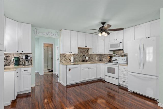 kitchen featuring dark hardwood / wood-style flooring, sink, white appliances, and white cabinets