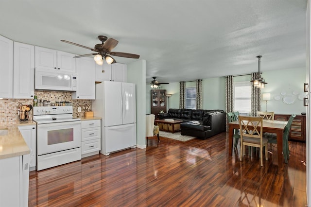 kitchen with dark hardwood / wood-style flooring, white cabinets, white appliances, and decorative light fixtures