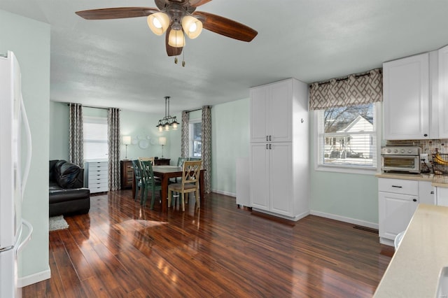 unfurnished dining area featuring dark wood-type flooring, ceiling fan, and plenty of natural light