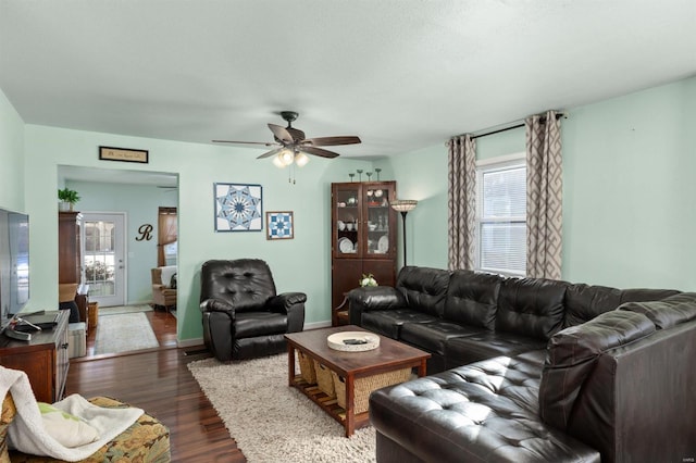 living room with dark wood-type flooring and ceiling fan