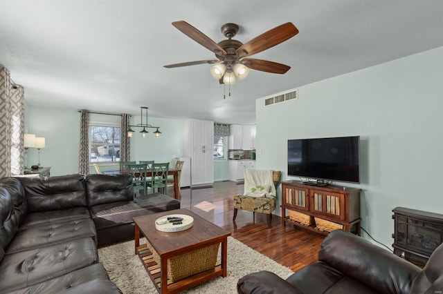 living room with dark wood-type flooring and ceiling fan