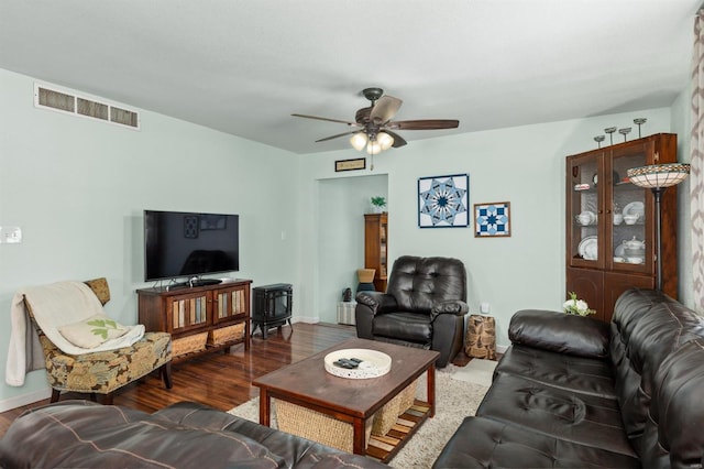 living room featuring dark wood-type flooring and ceiling fan