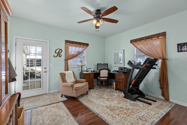 home office with dark wood-type flooring and ceiling fan