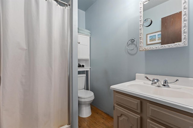 bathroom featuring vanity, hardwood / wood-style floors, and toilet